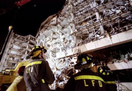 Firemen examine the wreckage of the federal building as night falls on downtown Oklahoma City, April..