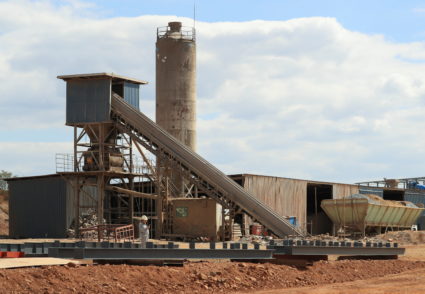 A worker checks their mobile phone at Prospect Lithium mine and processing plant in Goromonzi