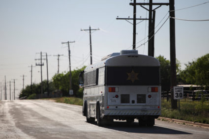 A bus leaves the Bluebonnet Detention Facility after dropping off detainees, in Anson