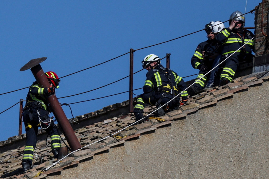 Members of the fire and rescue service set a chimney on the roof of the Sistine Chapel, ahead of the conclave, at the Vatican