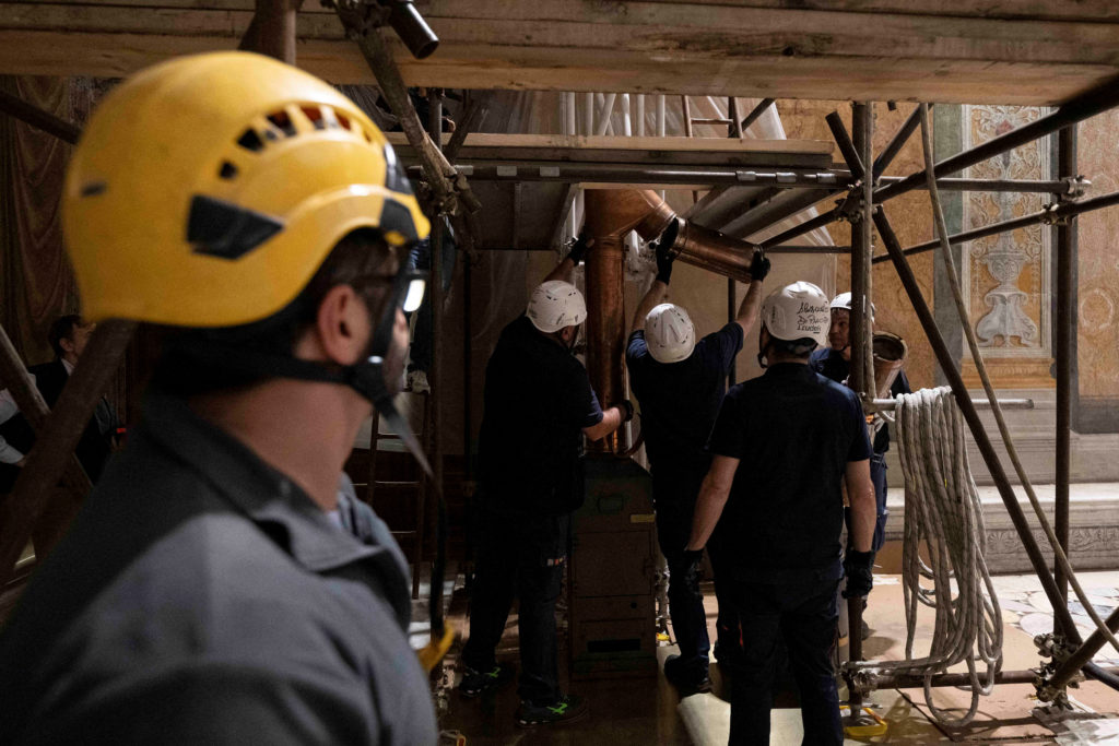 Workers install furnaces and chimney pipes at the Sistine Chapel, ahead of the conclave