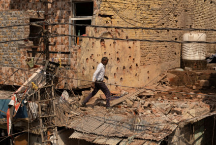 A man walks amidst debris on the roof of a damaged house, following Pakistan's military operation against India, in Rehari...