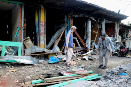 Residents assess the damage of their shops after it was hit in an Indian strike in Jura village in Neelum Valley