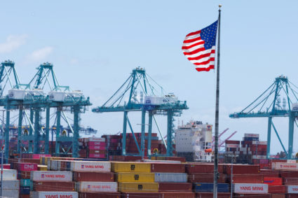 FILE PHOTO: The American flag flutters near a ship at Port of Los Angeles