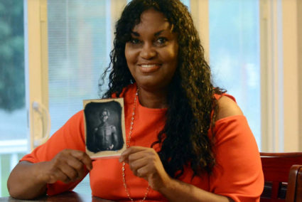 Tamara Lanier holds a copy of an 1850 photo of her enslaved ancestor "Papa Renty" Taylor in Norwich