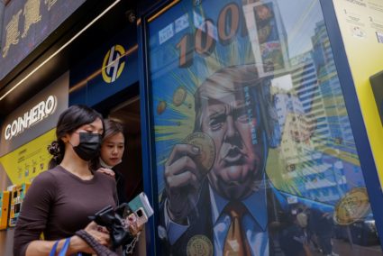 An illustration featuring U.S. President-elect Donald Trump holding Bitcoin is displayed outside a cryptocurrency exchange...