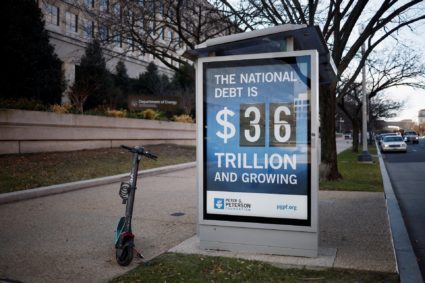 A poster displays at a bus shelter the current U.S. National debt at 36 Trillion dollars in Washington