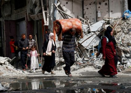 Palestinians make their way with belongings as they flee their homes, in the northern Gaza Strip