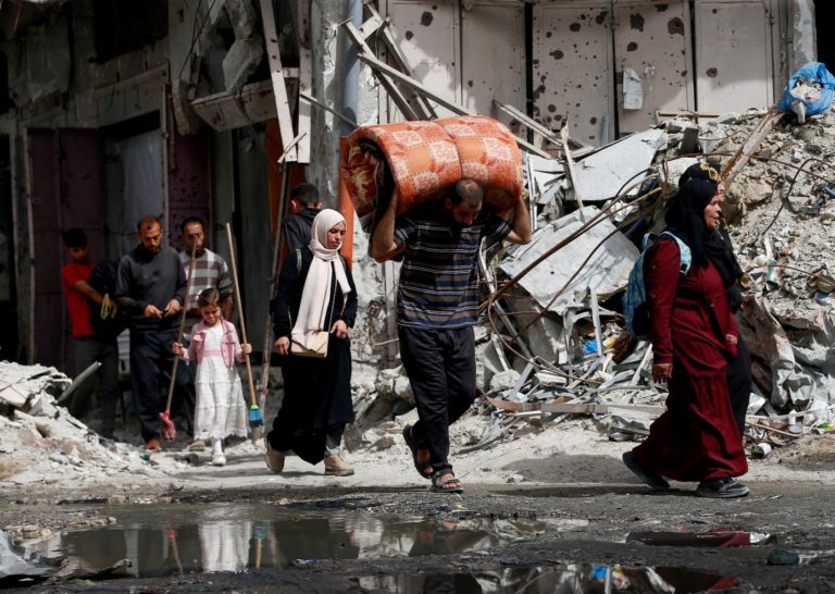 Palestinians make their way with belongings as they flee their homes, in the northern Gaza Strip