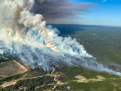 FILE PHOTO: Smoke rises from wildfire SWF076, which has prompted a one-hour evacuation notice for the nearby town of Swan ...