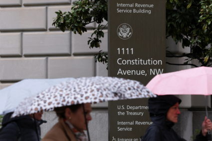 People walk in the rain past the Internal Revenue Service (IRS) building in Washington