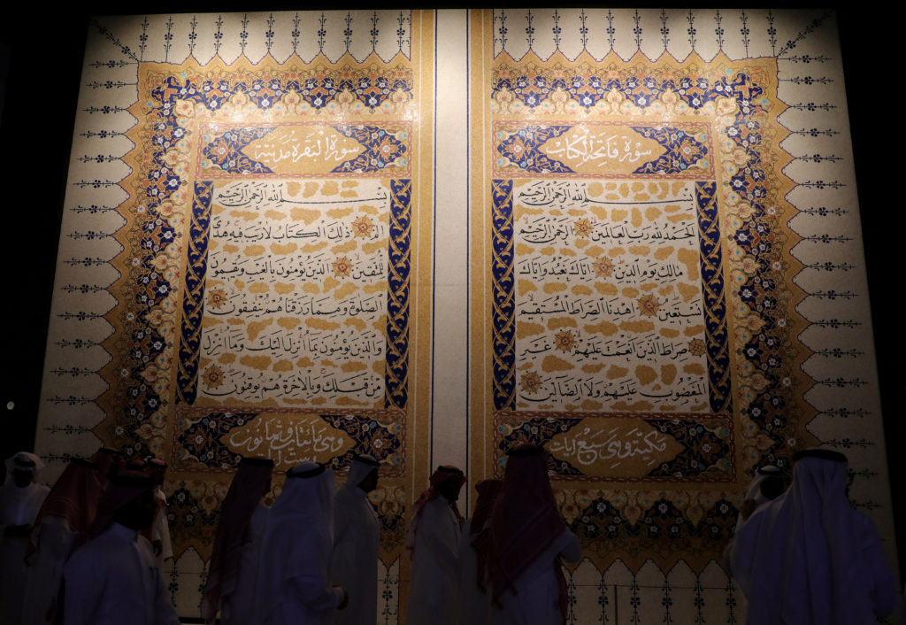 People walk past a marble mosaic of the Koran at a museum near the holy city of Mecca