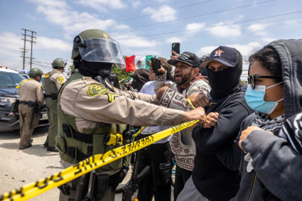 Los Angeles County Sheriff's deputy holds back protesters in Paramount