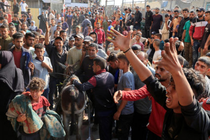 People react as Palestinian casualties, who were waiting to receive aid, are brought into Nasser hospital following an Isr...