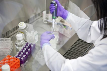 Researcher uses a micro-pipette in a laboratory