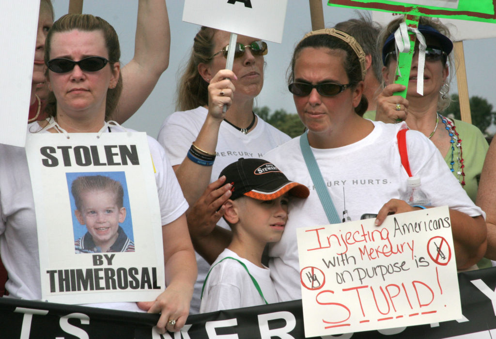 Demonstrators carry signs against the us