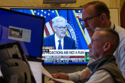 Traders work, as a screen broadcasts a news conference by U.S. Federal Reserve Chair Jerome Powell on the floor of the NYS...