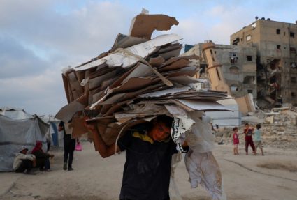 Palestinians gather to receive aid supplies, in Beit Lahia