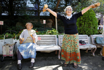 Natsu Naruse, 100 year-old, and other partcipants exercise with wooden dumbbells during a health promotion event to mark J...