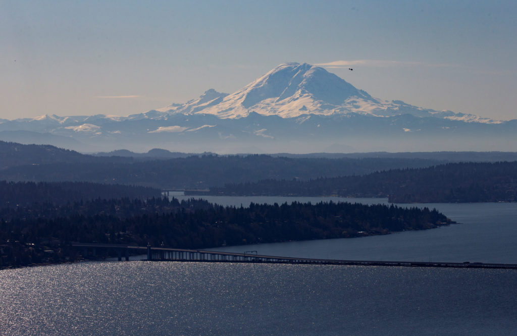 A helicopter flies over Lake Washington with Mt Rainier in the background during the outbreak of coronavirus disease (COVI...