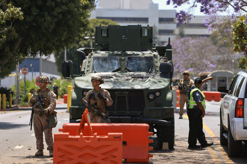 U.S. Marines stand watch at a checkpoint as they guard a federal building, in Los Angeles