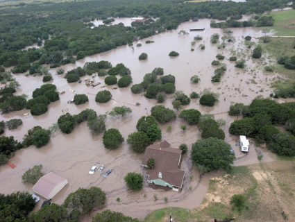 Houses and cars are partially submerged in flood waters in an aerial view near Kerrville