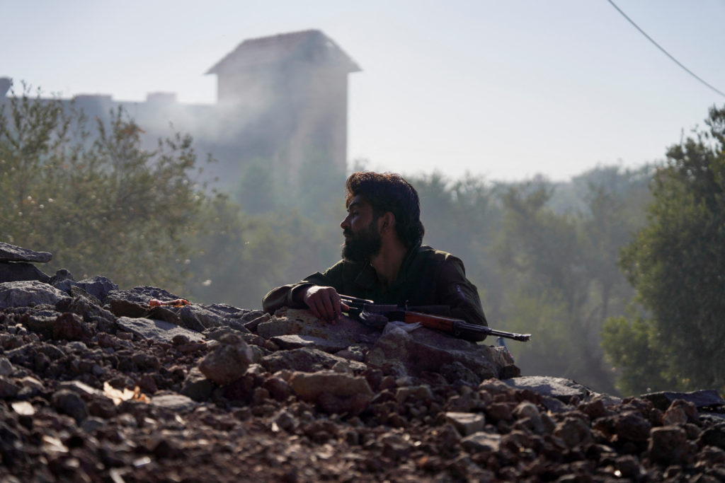 A bedouin fighter stands while holding his weapon, in Sweida