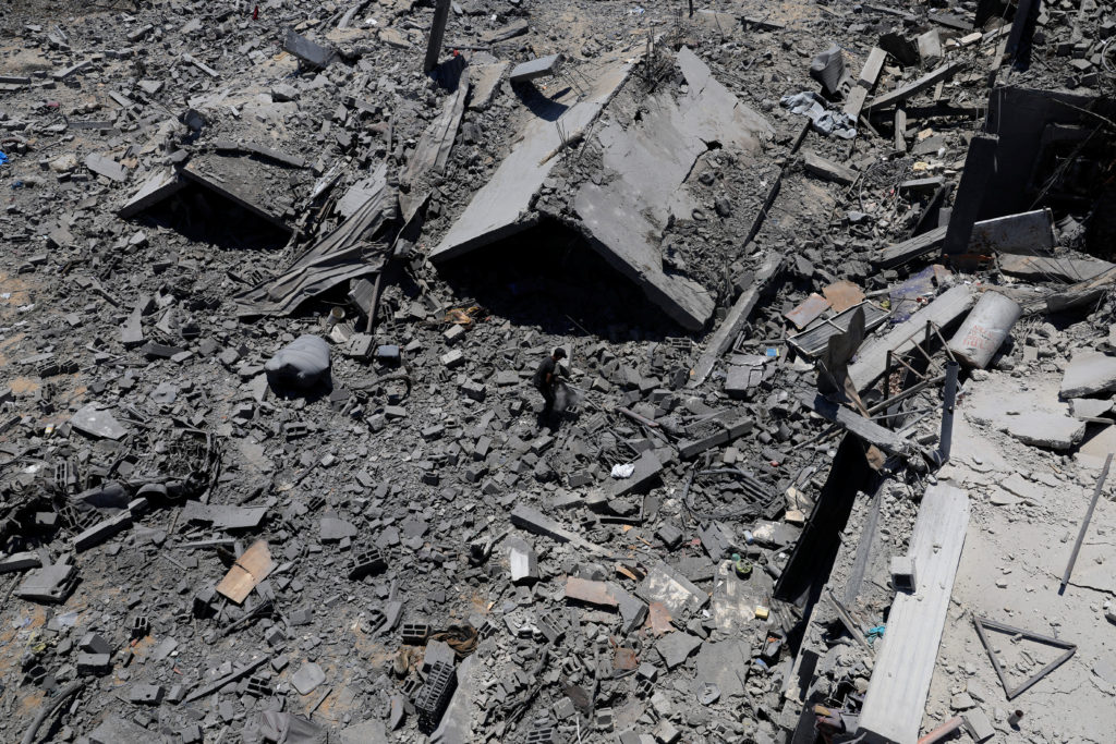 Palestinians inspect houses destroyed during an Israeli military operation, in Deir al-Balah