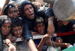 Palestinians wait to receive food from a charity kitchen, in Gaza City