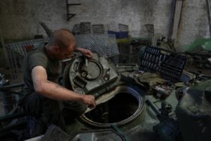 Ukrainian serviceman repairs a tank at a repair facility in an undisclosed location in eastern Ukraine