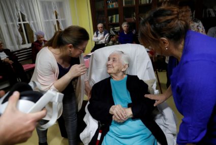Terez Redai, 88, talks with Margareta nursing home employees after using VR goggles, in Kecskemet