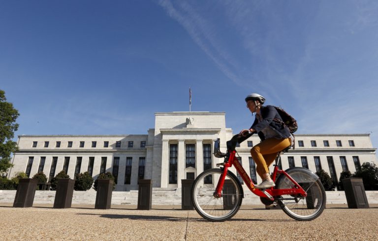 FILE PHOTO: Cyclist passes the Federal Reserve in Washington