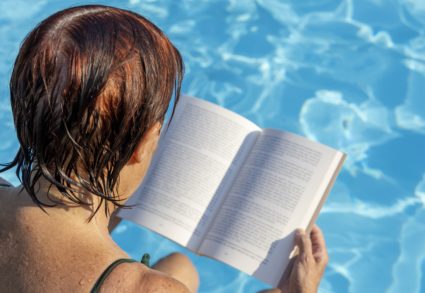 Older lady reading at the pool