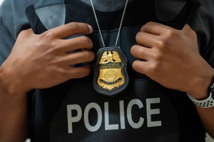 A U.S. Customs and Border Protection officer holds his tactical vest at U.S. immigration court in Manhattan