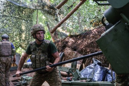 Ukrainian service member cleans a barrel of a howitzer after fire towards Russian troops, at a position in a front line in...