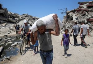 Palestinians carry aid supplies that entered Gaza through Israel, in Beit Lahia