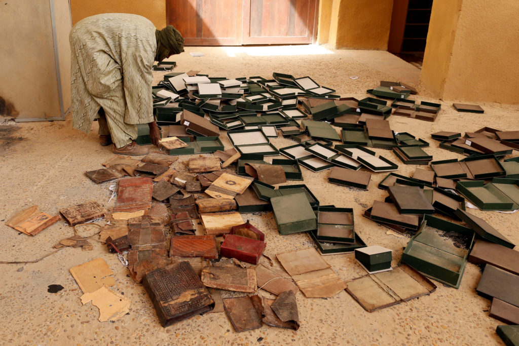 A museum guard sorts through burnt ancient manuscripts at the Ahmed Baba Institute in Timbuktu