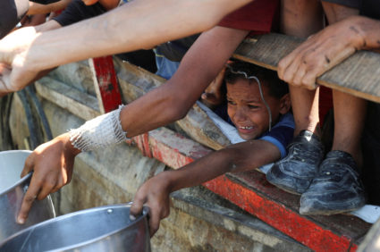Palestinians wait to receive food from a charity kitchen, amid a hunger crisis, in Gaza City