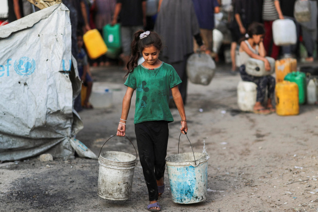 Palestinians wait to collect water amid shortages, in Gaza City