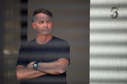 FILE PHOTO: Brazil’s former President Jair Bolsonaro stands at his home while under house arrest, in Brasilia