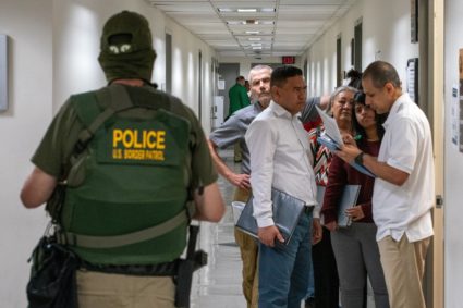 A migrant is detained by federal immigration officers at U.S. immigration court