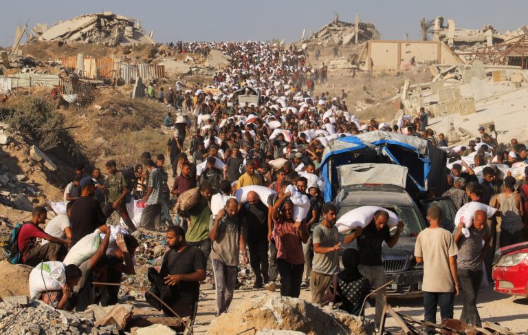 Palestinians carry aid supplies that entered Gaza through Israel, in Beit Lahia