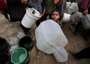 Displaced Palestinians fill water containers at a tent camp, in Gaza City