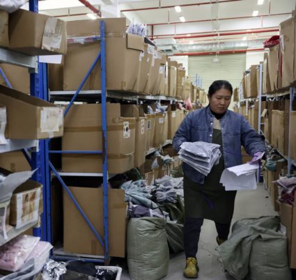 Employee picks up lingerie products at the warehouse of the Midnight Charm Garment lingerie factory in Guanyun