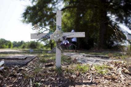 A wooden cross adorns a gravesite at the St James AME Church Cemetery before mourners attend the burial of Reverend Clemen...