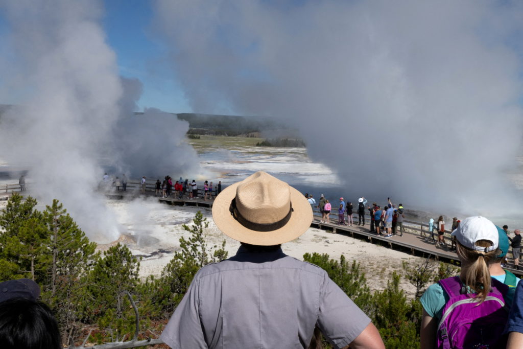 National Park Service Seasonal Interpretation Ranger Denine Northup watches as three geysers erupt simultaneously during h...