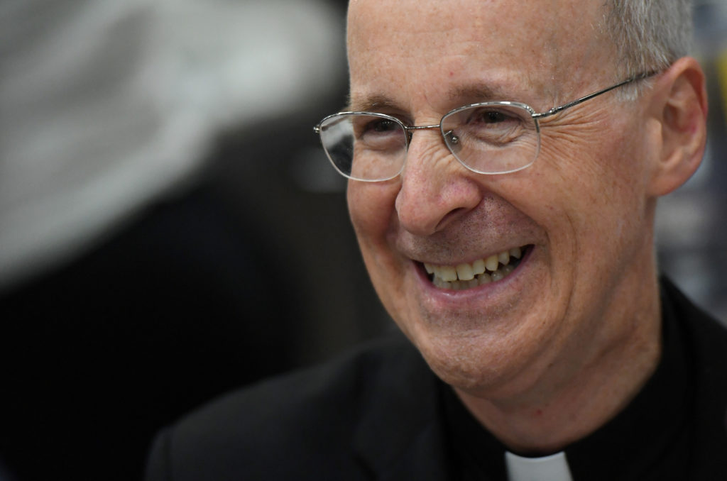 FILE PHOTO: Jesuit priest father James Martin of the U.S. smiles as he signs copies of his book at the Pastoral Congress a...