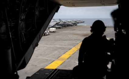 AV-8B Harrier II attack aircrafts are seen from an MV-22 Osprey transport aircraft landing aboard the U.S. Navy amphibious...