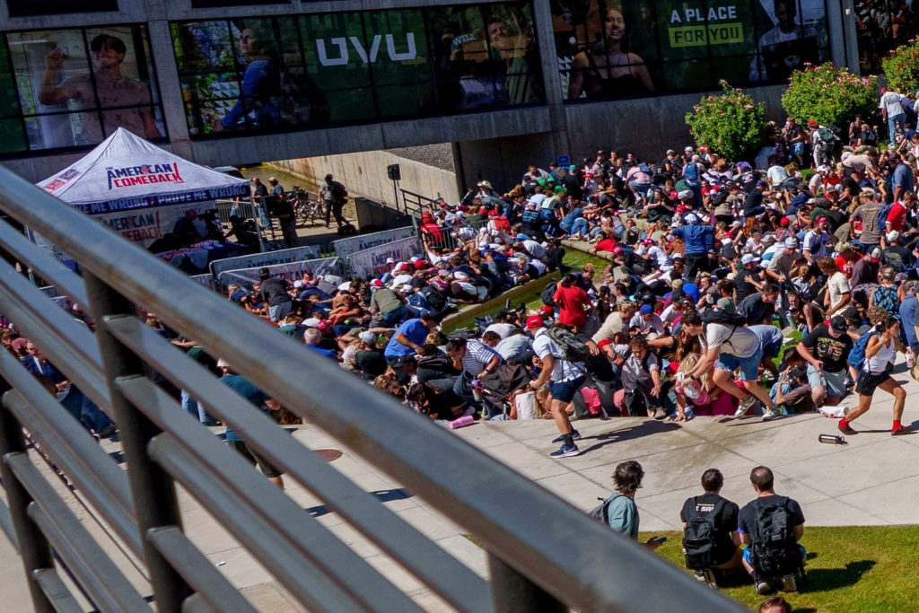People run and crouch after U.S. right-wing activist and commentator Charlie Kirk was shot at a Utah Valley University spe...