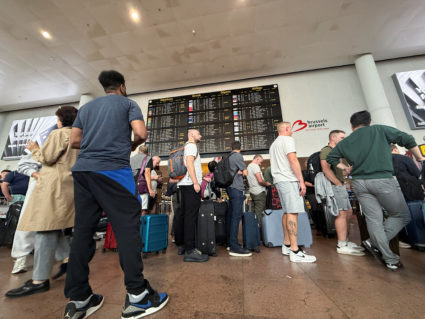 Travelers wait as a cyberattack impacts Brussels airport